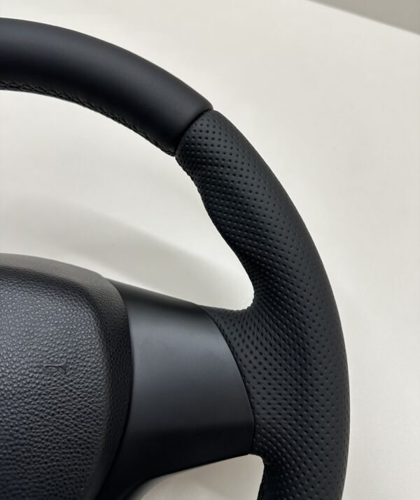 Top right view of a buttonless BMW M Sport steering wheel for E90 E92 E87 E82 with black stitches
