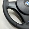 bottom left view of a buttonless BMW M Sport steering wheel for E90 E92 E87 E82 with black stitches